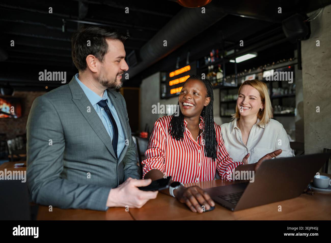 Colleghi aziendali diversi che collaborano e discutono idee in un bar Foto Stock