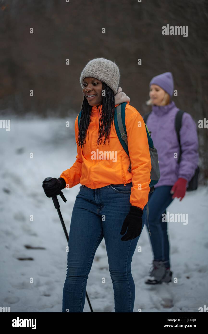 Due persone si divertono a fare escursioni invernali su un sentiero innevato Foto Stock