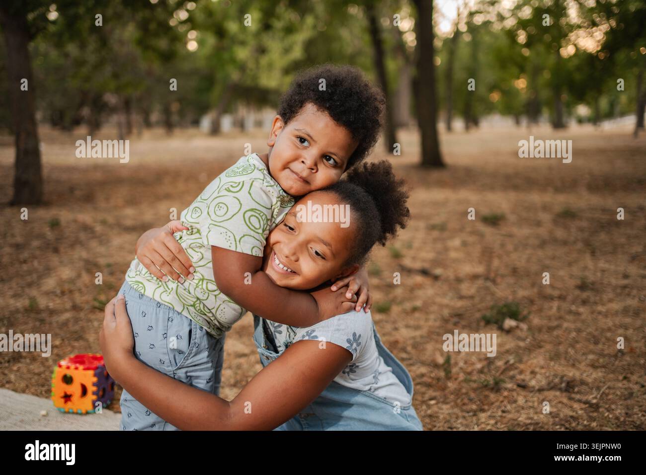 Due bambini afroamericani che si abbracciano in un parco Foto Stock