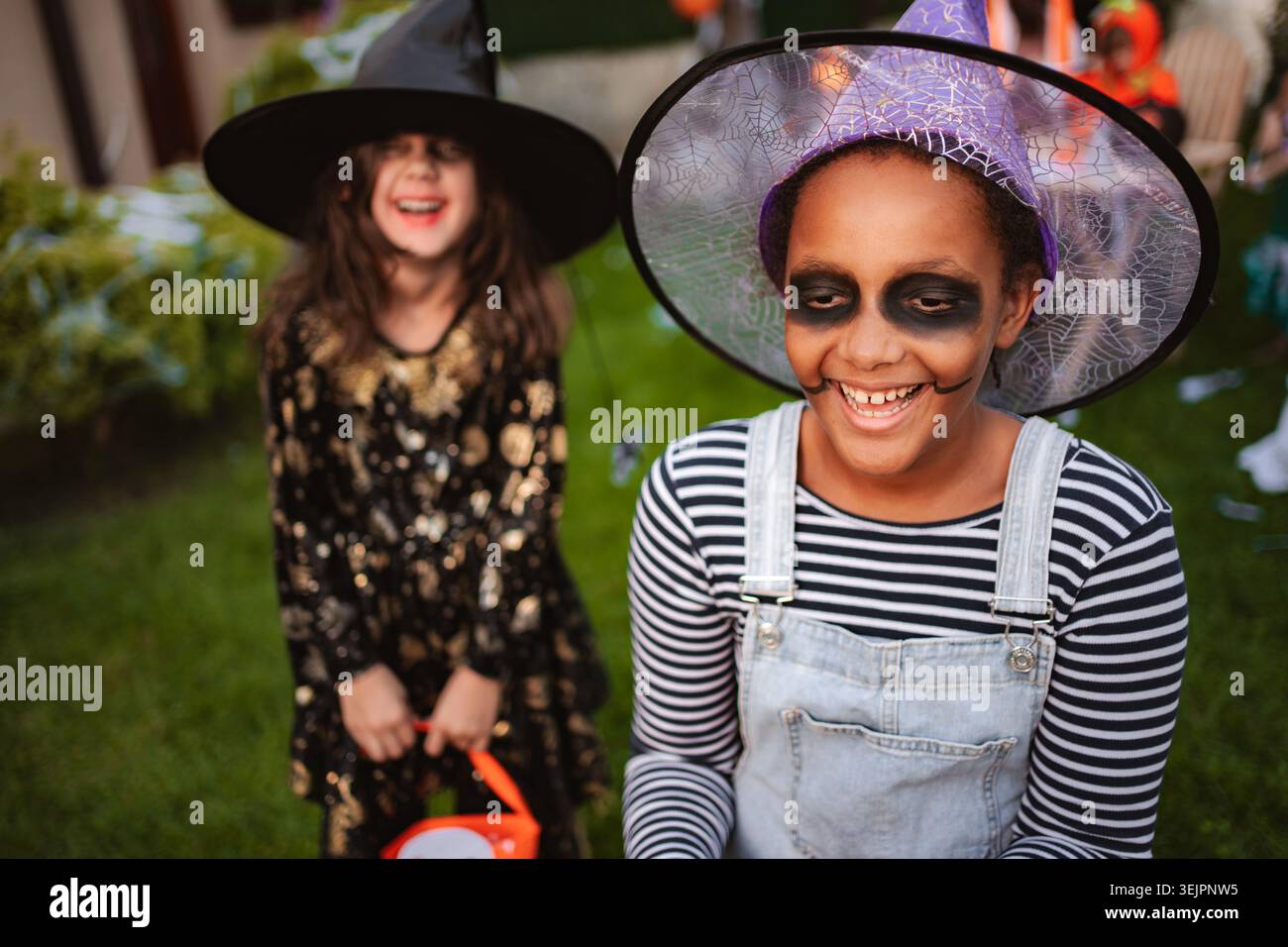 Due ragazze allegre che indossano costumi di Halloween e trucco stanno ridendo insieme Foto Stock