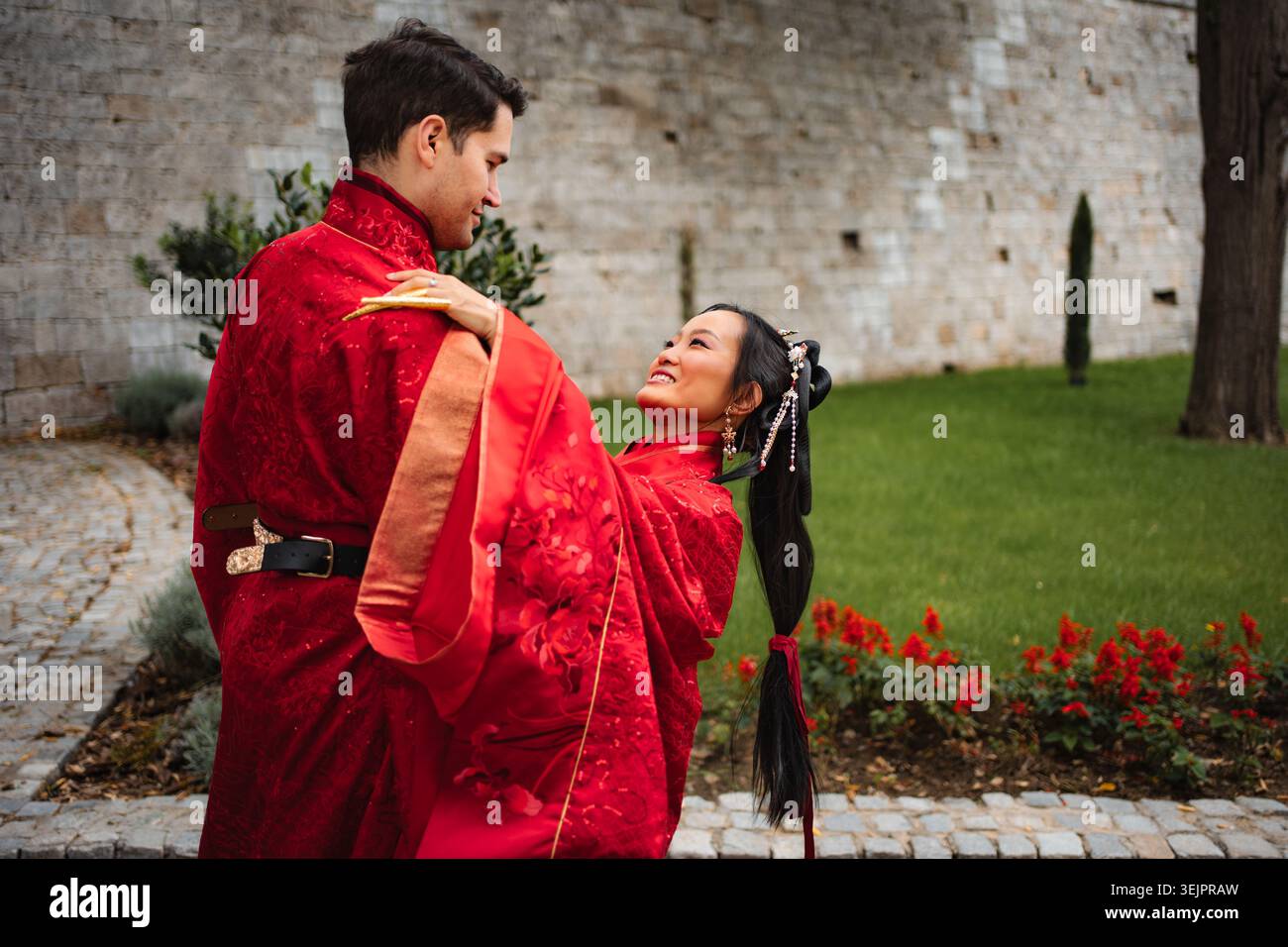 Coppia interculturale che celebra il matrimonio in abiti tradizionali cinesi Foto Stock