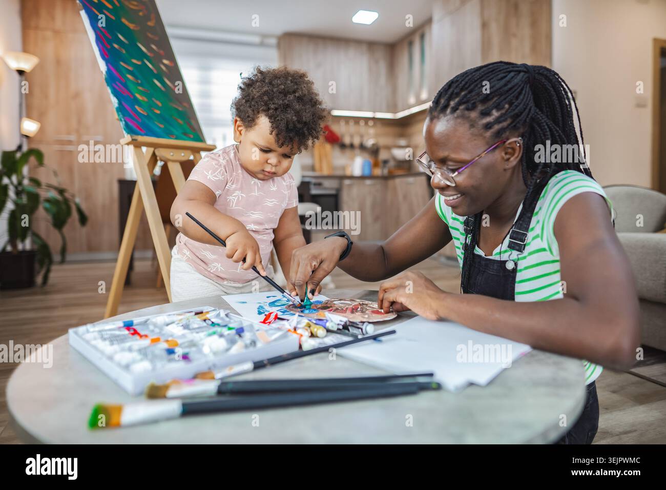 Legame creativo tra madre e bambino in un accogliente studio Foto Stock