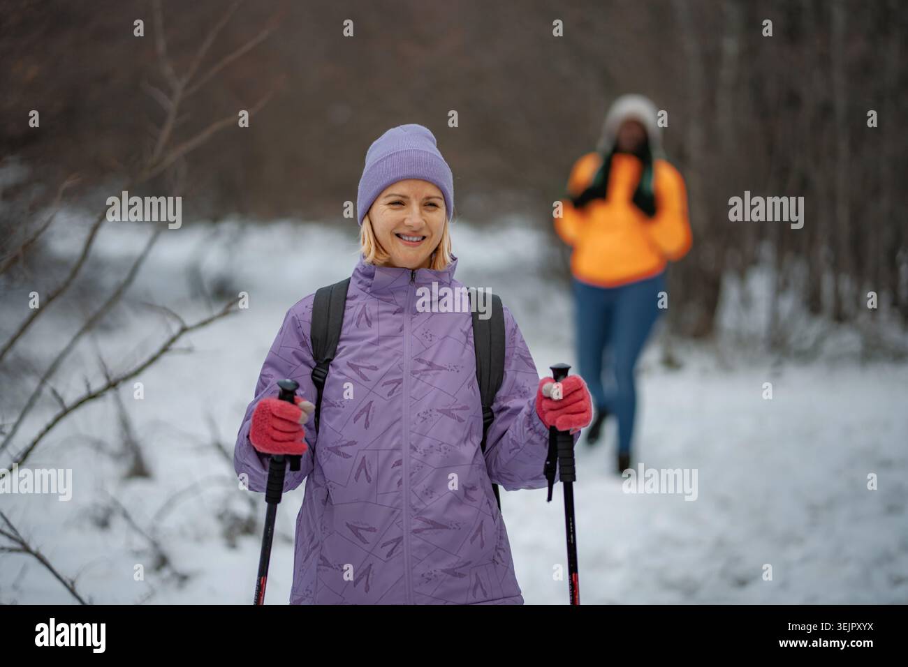 Donna nordic walking nella foresta invernale godendo della natura Foto Stock