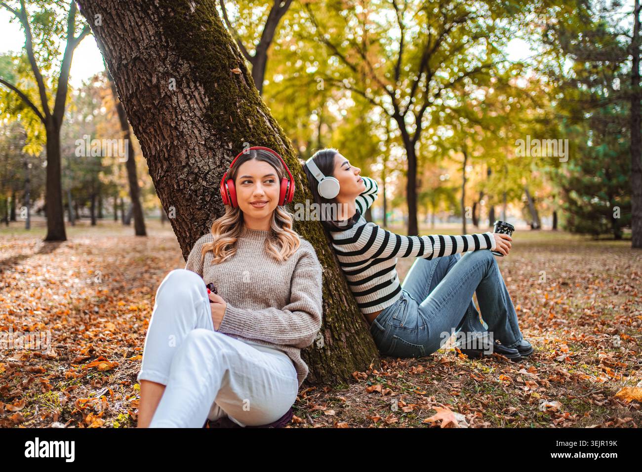 Godendosi l'atmosfera autunnale insieme, due ragazze condividono momenti tranquilli nel parco Foto Stock