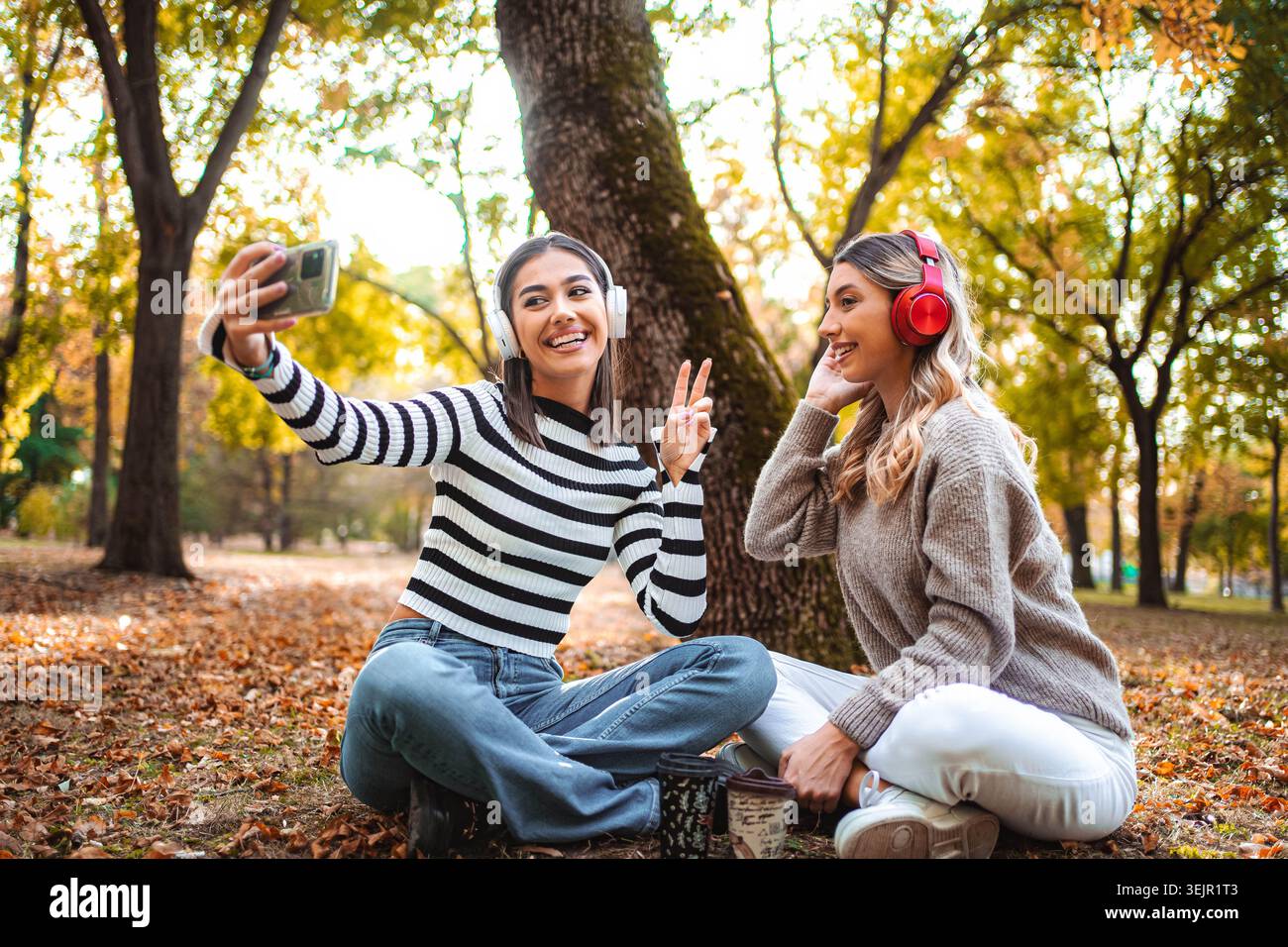 Sorrisi e ricordi condivisi da due ragazze in un accogliente parco autunnale Foto Stock