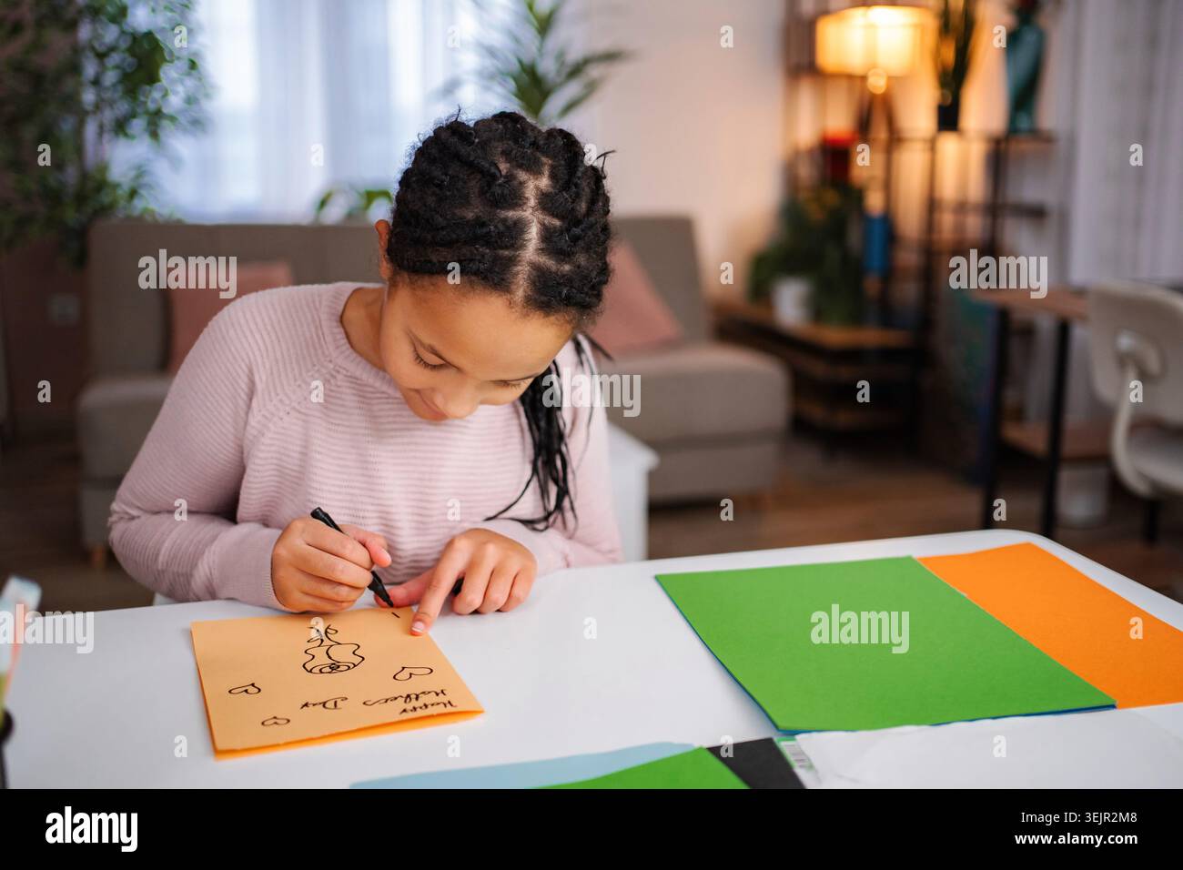 Ragazza che disegna il biglietto per la festa della mamma Foto Stock