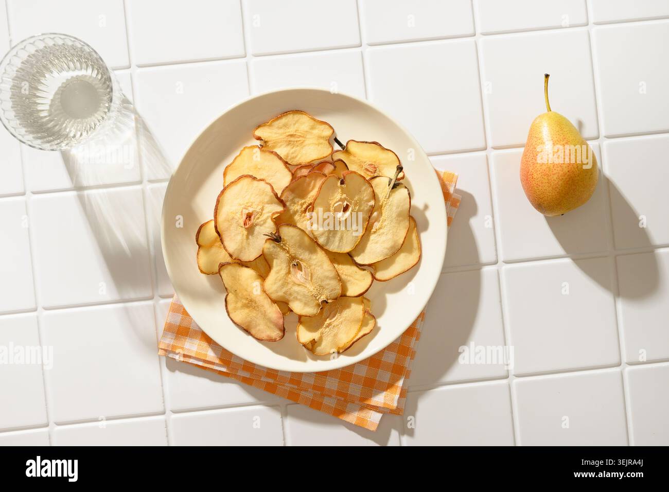 Frutta, patatine di pera e acqua all'ombra del sole. Dessert vegano senza zucchero. Foto Stock