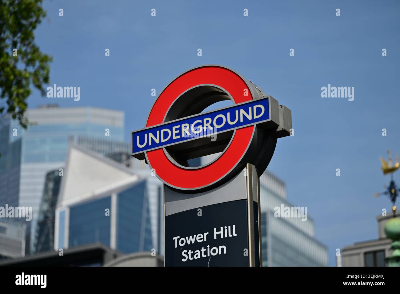 Iconica rotonda della metropolitana alla stazione di Tower Hill, contro edifici in vetro e cielo Foto Stock