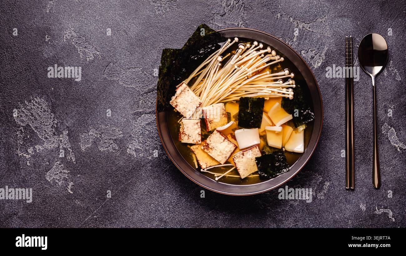 Zuppa in stile asiatico con calamari, tofu e funghi enoki. Vista dall'alto. Foto Stock