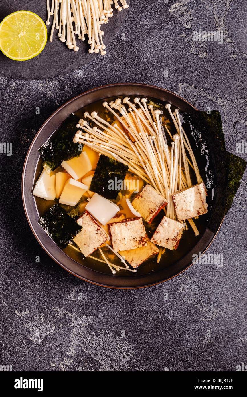 Zuppa in stile asiatico con calamari, tofu e funghi enoki. Vista dall'alto. Foto Stock