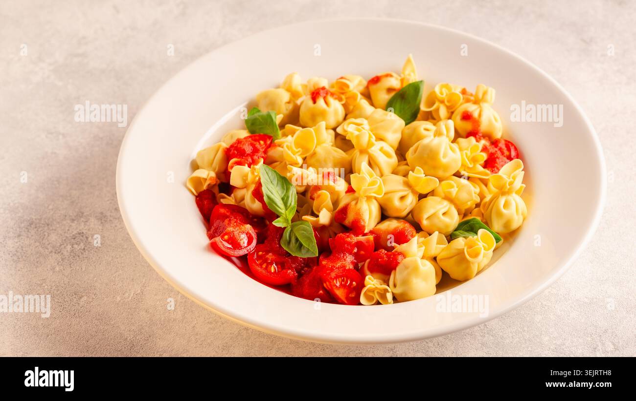 Pasta ripiena italiana. Sacсhettini pasta in un piatto con salsa di pomodoro. Foto Stock