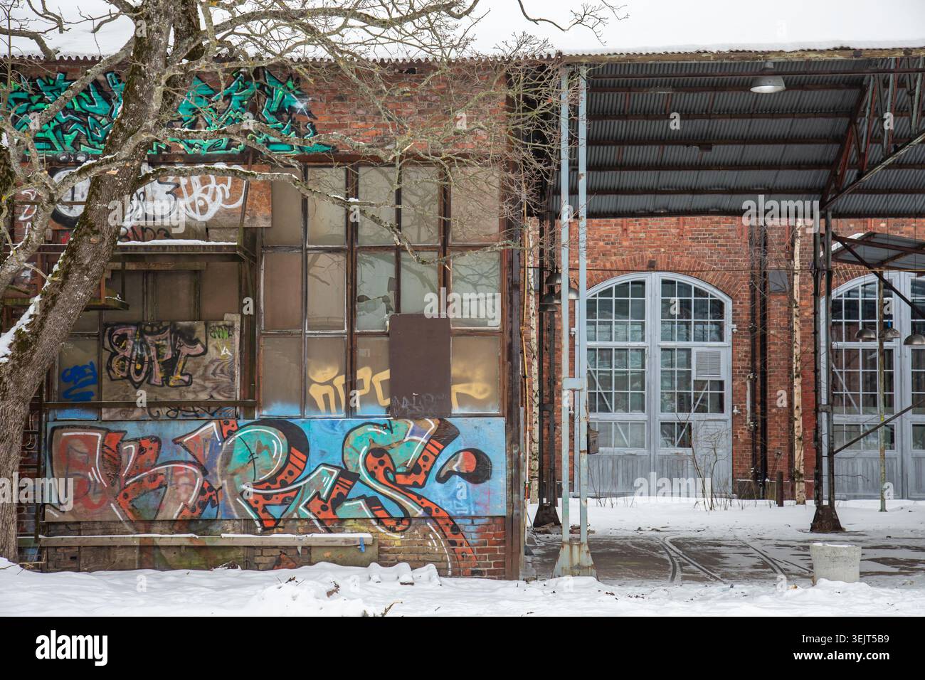 Vecchie sale industriali ricoperte di graffiti del quartiere Konepaja nel quartiere Vallila di Helsinki, Finlandia Foto Stock