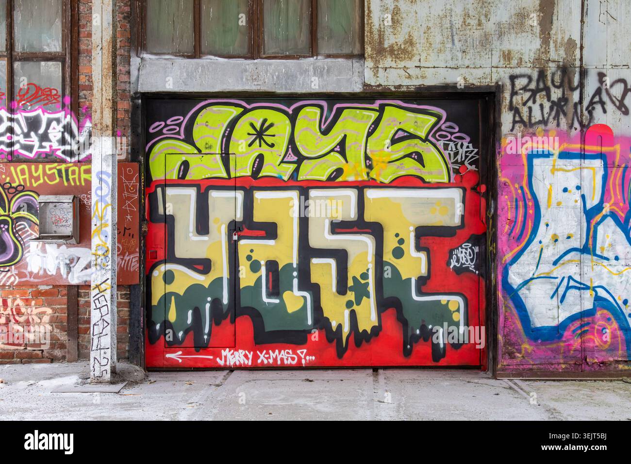 Vecchio edificio industriale ricoperto di graffiti nel distretto di Konepaja, Helsinki, Finlandia Foto Stock