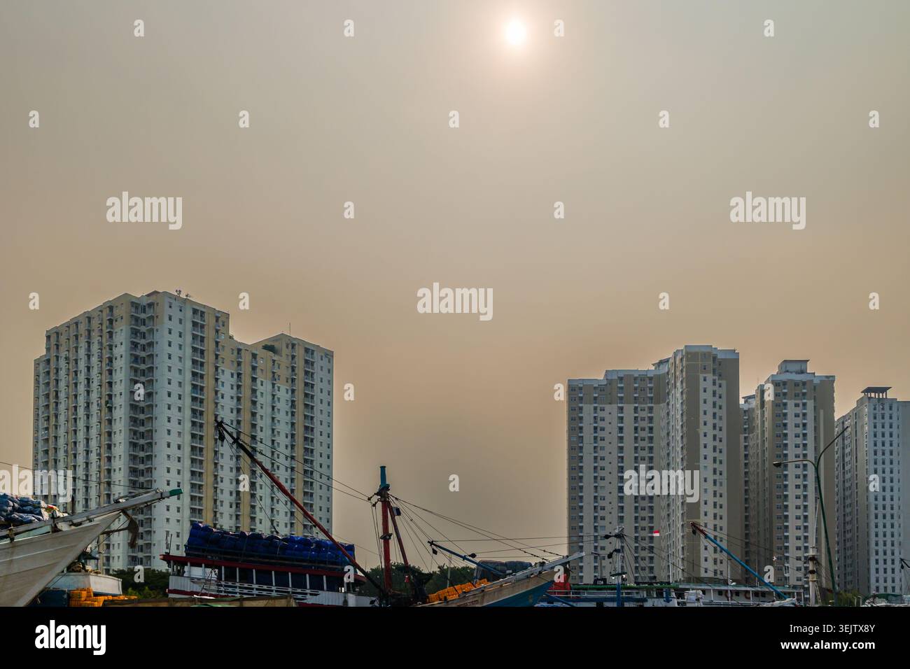 Barche Pinisi tradizionali ormeggiate al porto Sunda Kelapa sotto un cielo inquinato e nebuloso a Giacarta Foto Stock