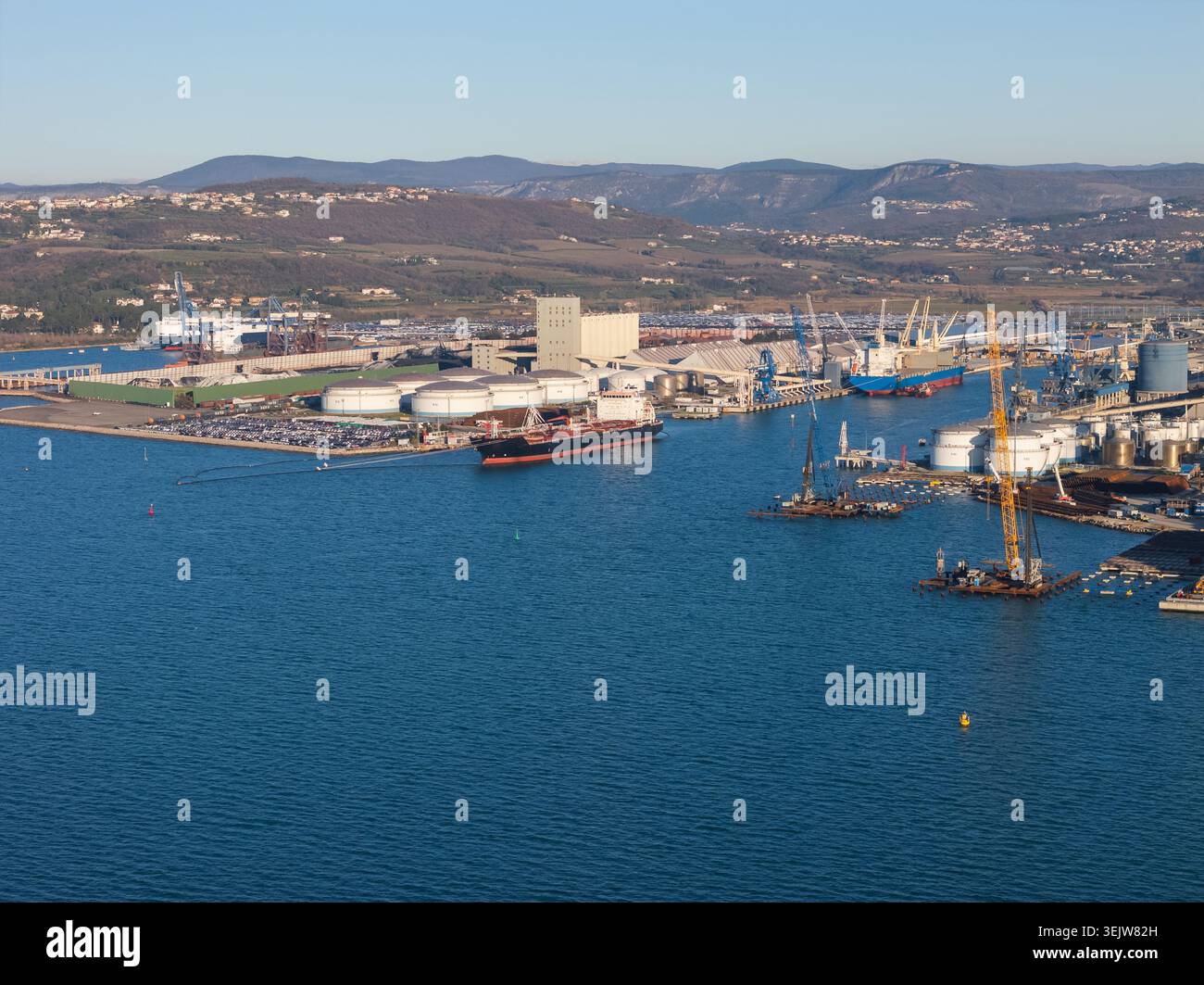 Porto commerciale affollato che mostra le petroliere al lavoro per il commercio globale di petrolio greggio e la gestione della catena di approvvigionamento. Foto Stock