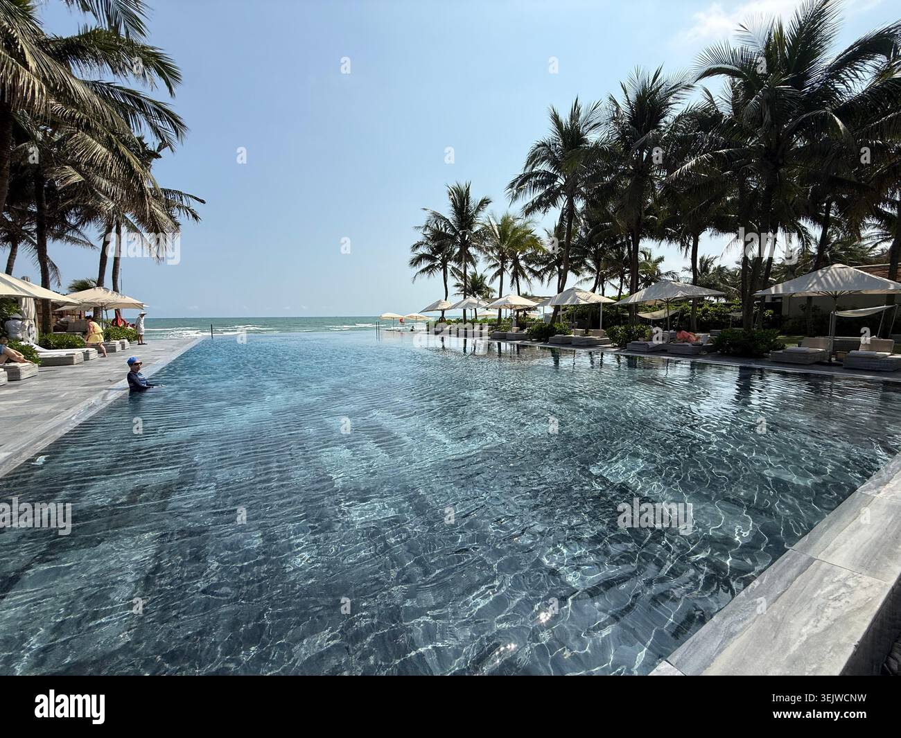 Una lussuosa piscina del resort benessere che si affaccia sul Mare del Vietnam Orientale, parte del Mare della Cina del Sud a da Nang (Danang) nel Vietnam centrale Foto Stock