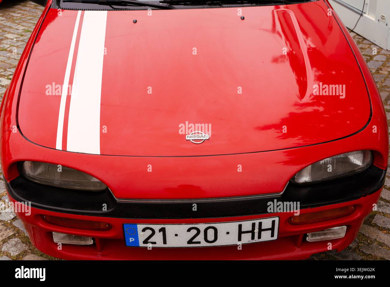 Maia - Porto - Portogallo , 30 maggio 2026: Nissan 100nx con cappuccio rosso, strisce bianche da corsa, emblema, fari e targa. Foto Stock