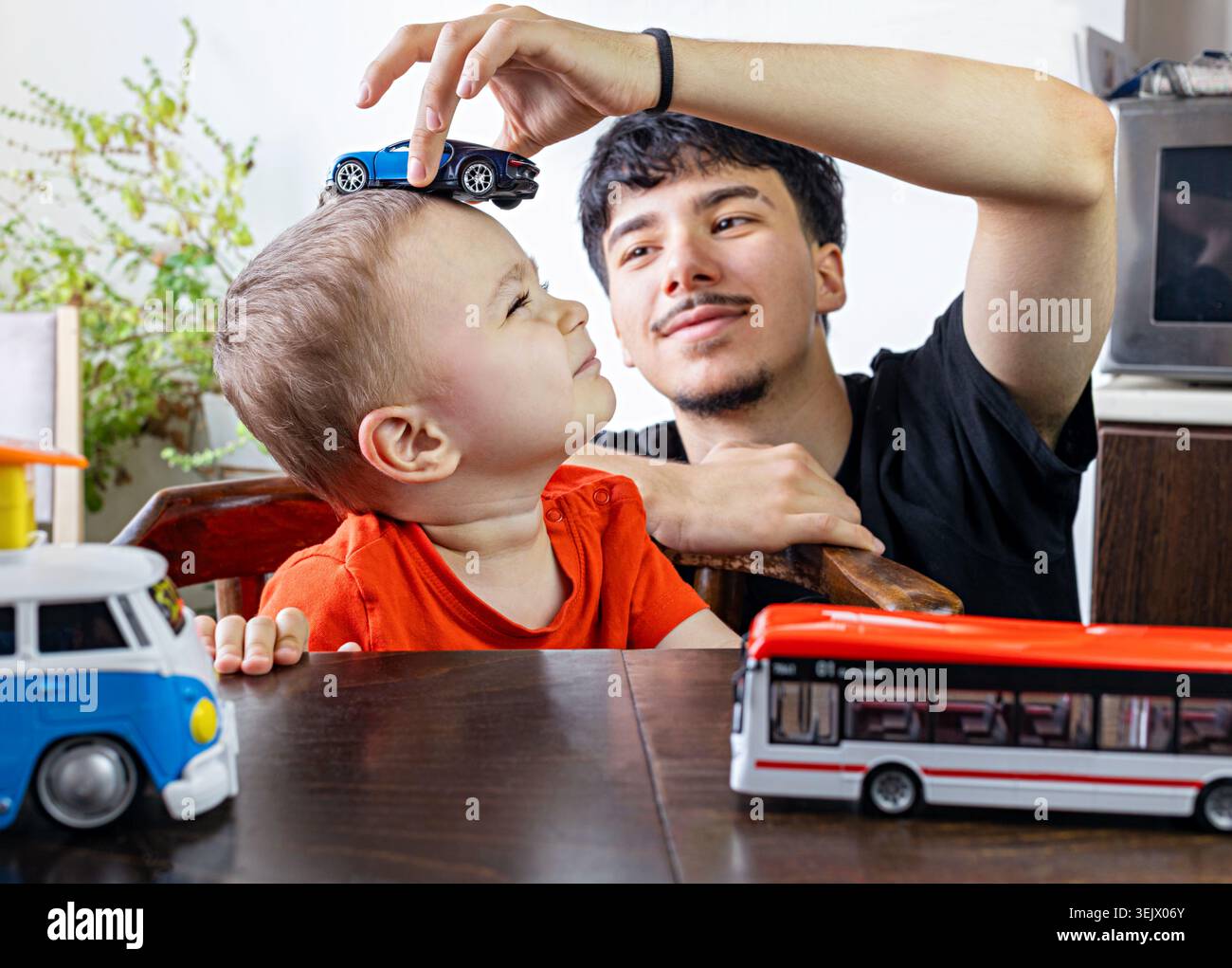 Due fratellastri ebrei - 2,5 e 17 anni stanno giocando con le auto modello. Foto Stock