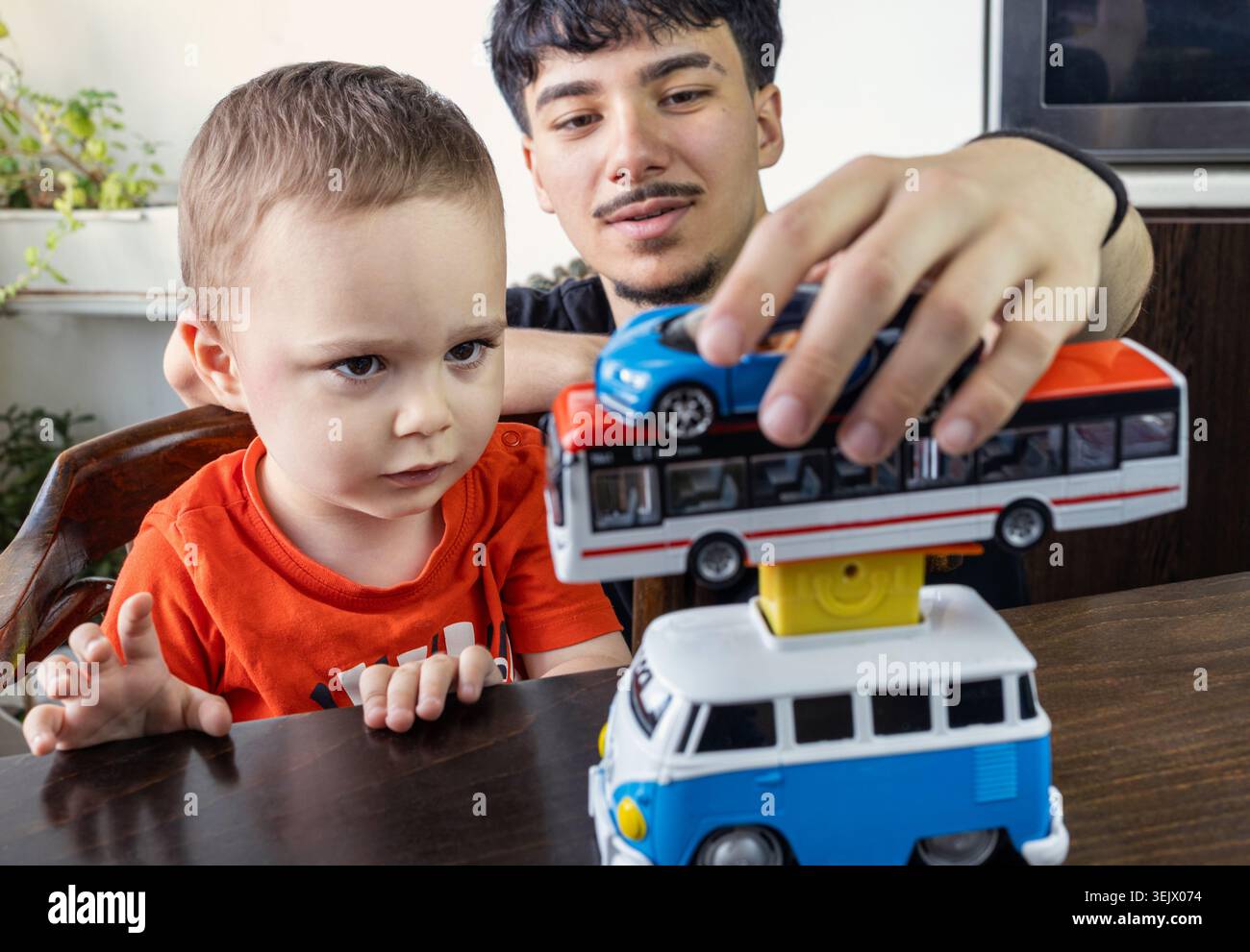 Due fratellastri ebrei - 2,5 e 17 anni stanno giocando con le auto modello. Foto Stock