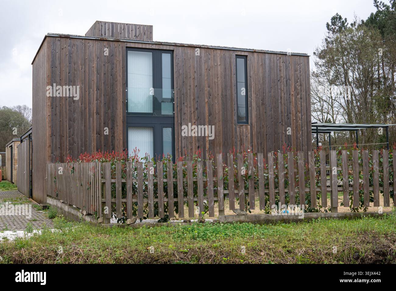 moderna casa in legno con tavole verticali e recinzione Foto Stock