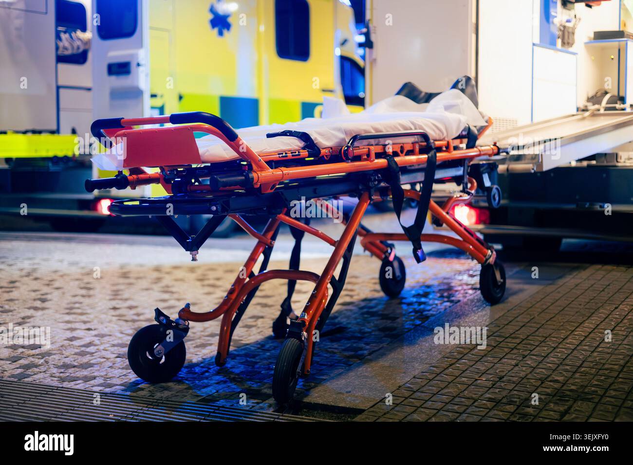 Barella pronta dietro le porte aperte dell'ambulanza di notte. Servizio medico di emergenza, assistenza urgente e concetto di assistenza sanitaria. Foto Stock