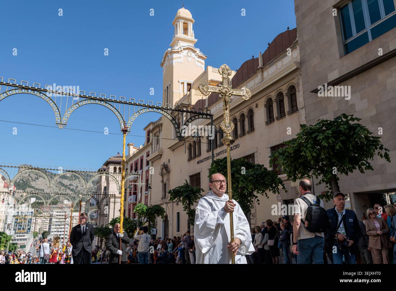 Accolyte che porta una croce processionale in via Santo Tomas presso il monastero di Santo Sepulcro, i Mori e i cristiani ad Alcoy il 26 aprile 2026, Spagna Foto Stock