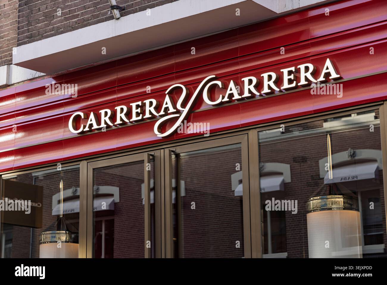 Primo piano dell'elegante logo e delle lettere dorate della boutique di gioielli di lusso Carrera y Carrera su una facciata rossa lucida su PC Hooftstraat. Amst Foto Stock