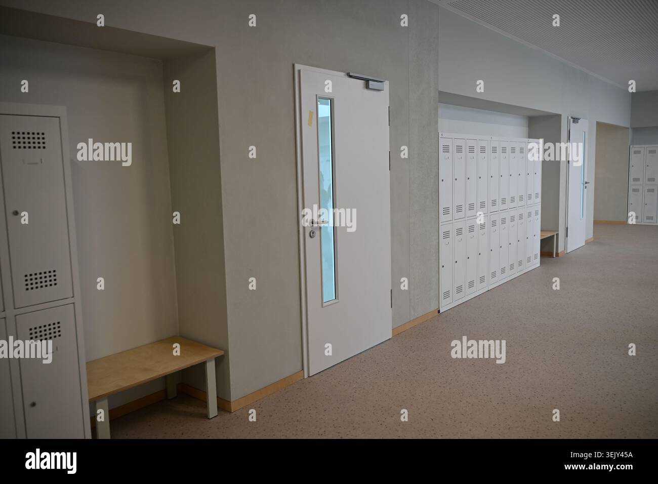 Corridoio scolastico moderno con armadietti in metallo bianco e porte ad aula a Breslavia Zwycięska Foto Stock