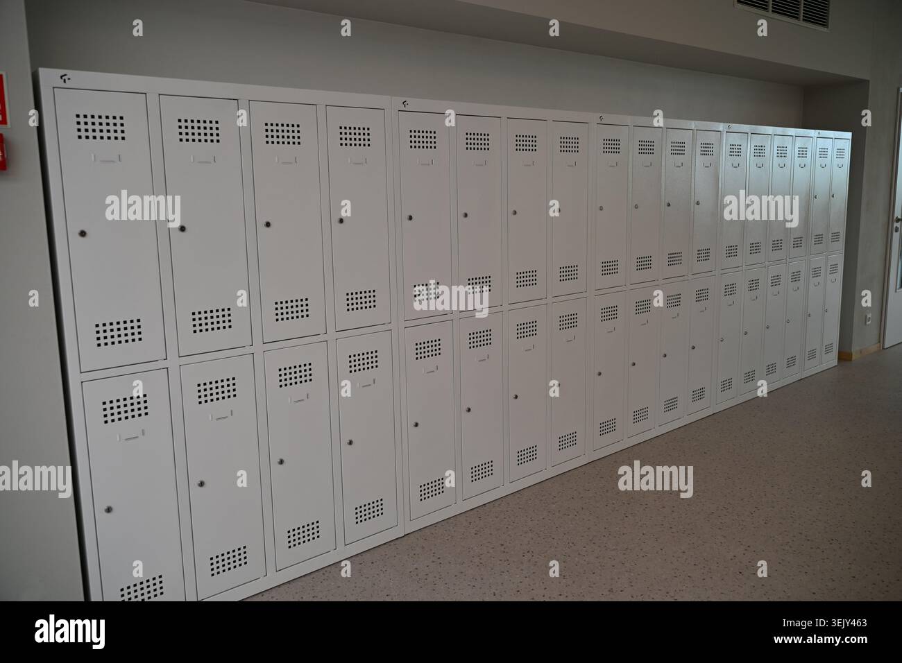 Corridoio scolastico moderno con armadietti in metallo bianco e porte ad aula a Breslavia Zwycięska Foto Stock