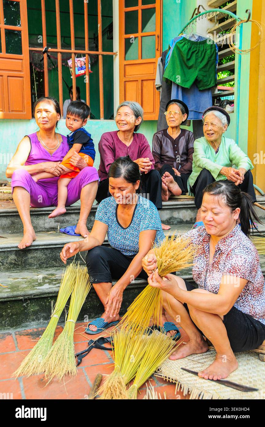 Tre generazioni di tessitori di bambù e erba nel villaggio Duc Thai Foto Stock