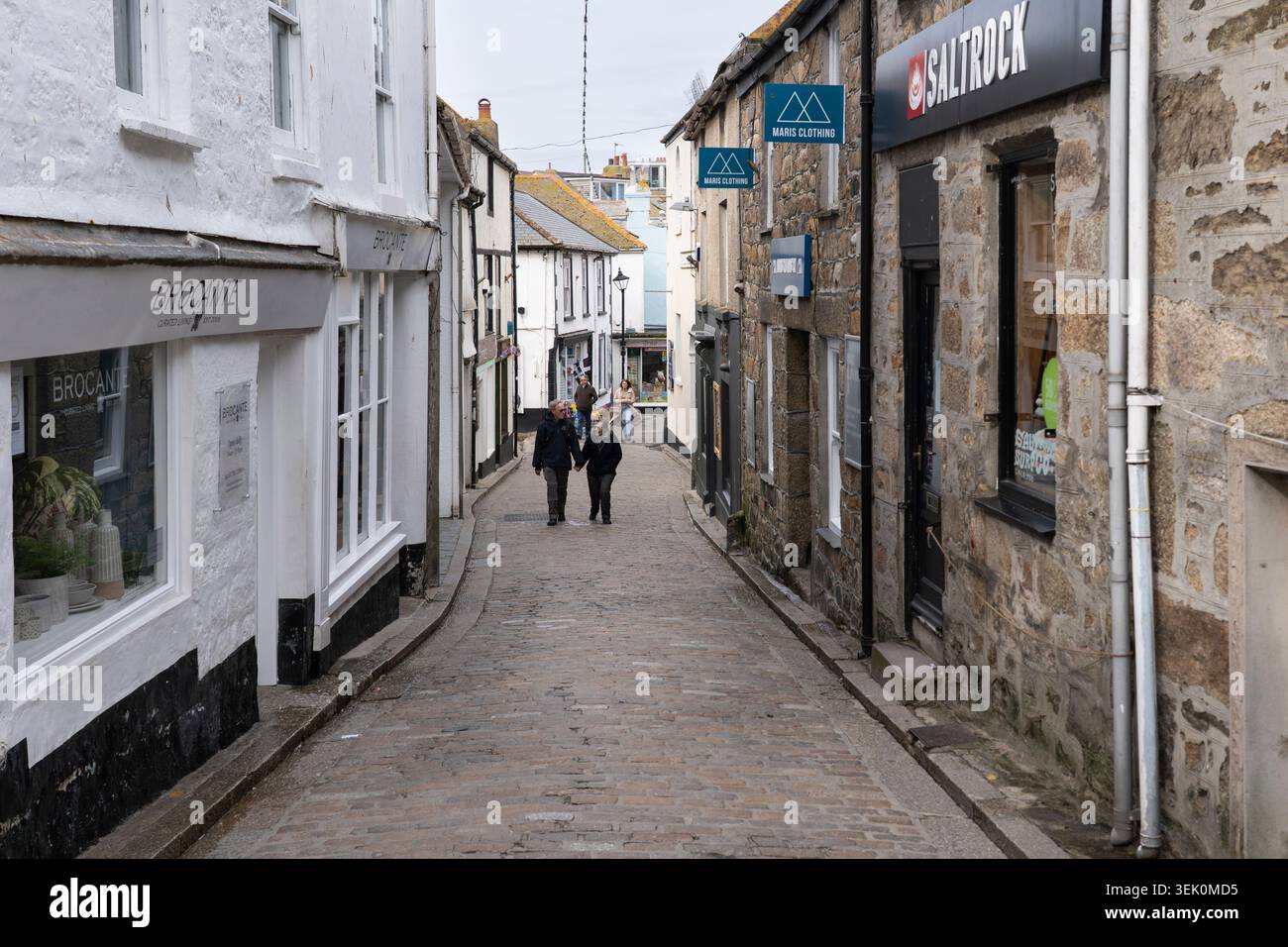 I turisti camminano lungo Fore Street, l'animata arteria principale acciottolata di St Ives, che corre parallela al porto, in Cornovaglia, Inghilterra Foto Stock