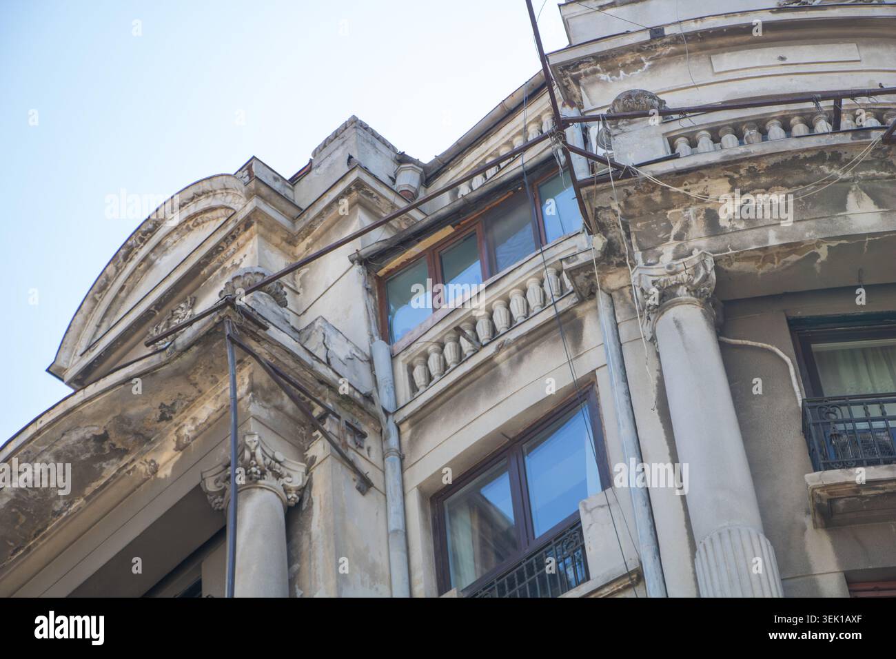 Vista ravvicinata di uno storico edificio residenziale a Bucarest, Romania, caratterizzato da colonne classiche ed elementi architettonici decorativi Foto Stock