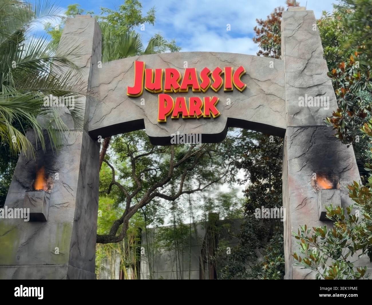 ORLANDO, Florida - 31 maggio 2026: L'iconico arco di ingresso in pietra al Jurassic Park fiancheggiato da palme e torce fiammeggianti all'Universal's Islands of Adventure Foto Stock