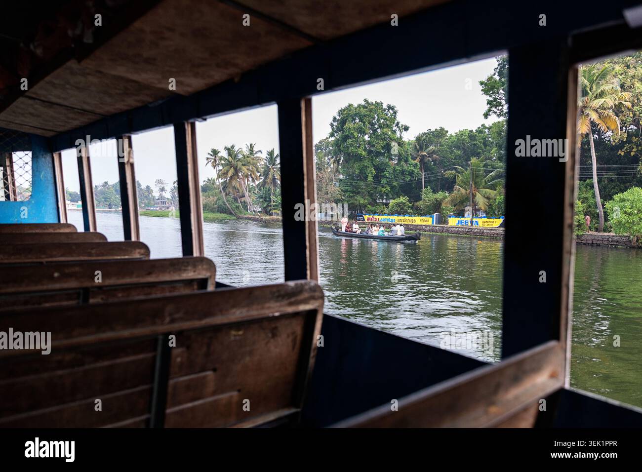 Banchi vuoti in legno all'interno di un traghetto pubblico locale che naviga nelle backwater di Alleppey (Alappuzha), Kerala, India. Foto Stock