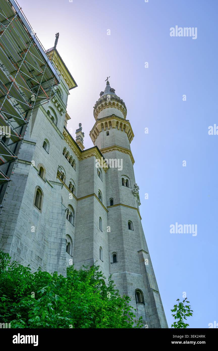 Schwangau, Germania - maggio 31 2026: Vista dall'angolo basso della storica torre del castello di Neuschwanstein con impalcature di costruzione sulla facciata sinistra sotto a. Foto Stock