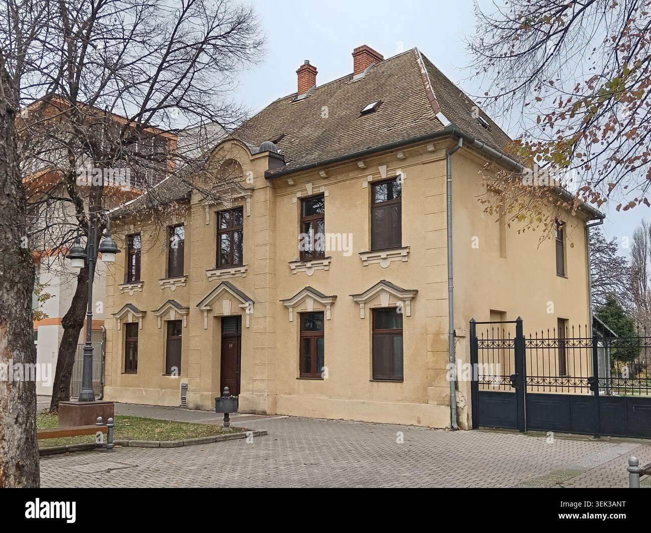 Un bellissimo edificio storico municipale dall'architettura tradizionale, facciata gialla rinnovata ed elementi decorativi sulle finestre. Foto Stock