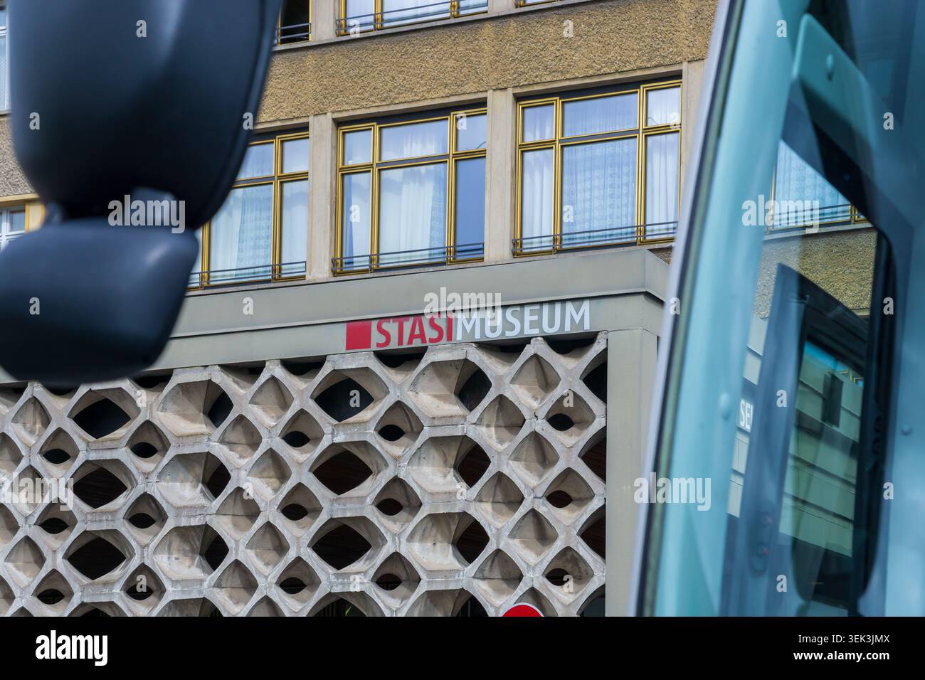 L'ingresso e la segnaletica del Museo della Stasi sono visibili attraverso le finestre e gli specchi di un autobus turistico parcheggiato presso l'ex Ministero della sicurezza dello Stato. Foto Stock