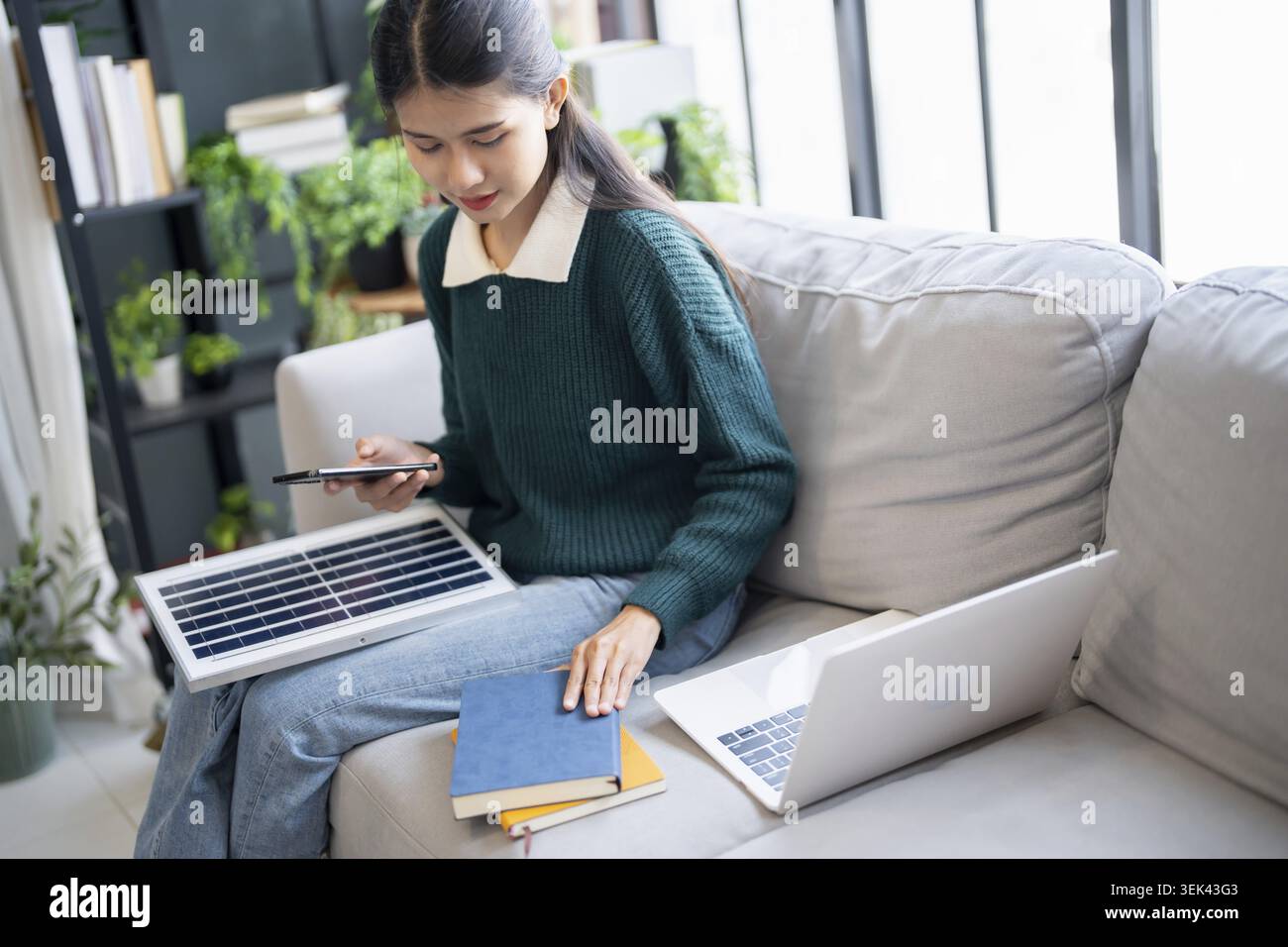 I proprietari di case installano sistemi solari nella loro casa donna asiatica impara a conoscere la tecnologia sostenibile Foto Stock