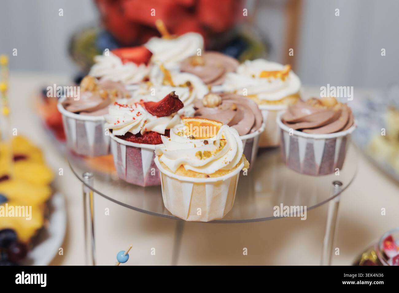 I delicati cupcake si appoggiano su un supporto a due piani trasparente Foto Stock