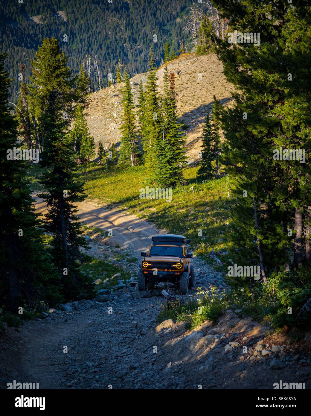 SUV robusto che sale su un sentiero roccioso in montagna Foto Stock