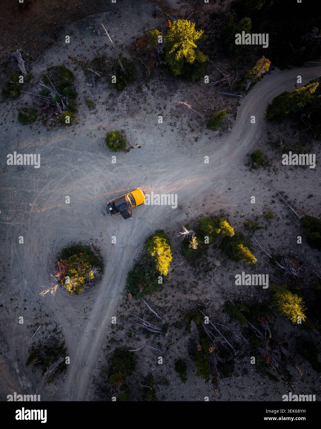 Veicolo fuoristrada giallo parcheggiato su una strada sterrata tortuosa Foto Stock