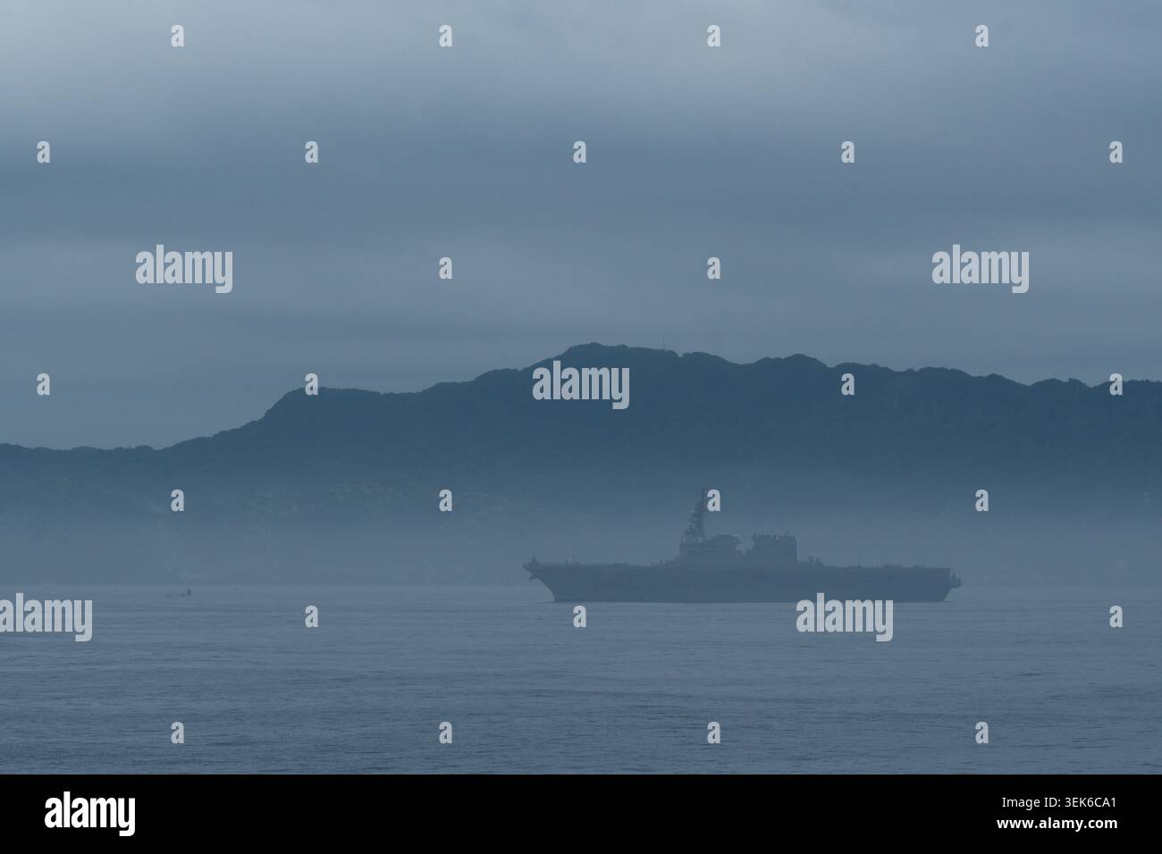 Il cacciatorpediniere JMSDF Hyuga naviga attraverso la fitta nebbia nella baia di Tokyo all'alba Foto Stock