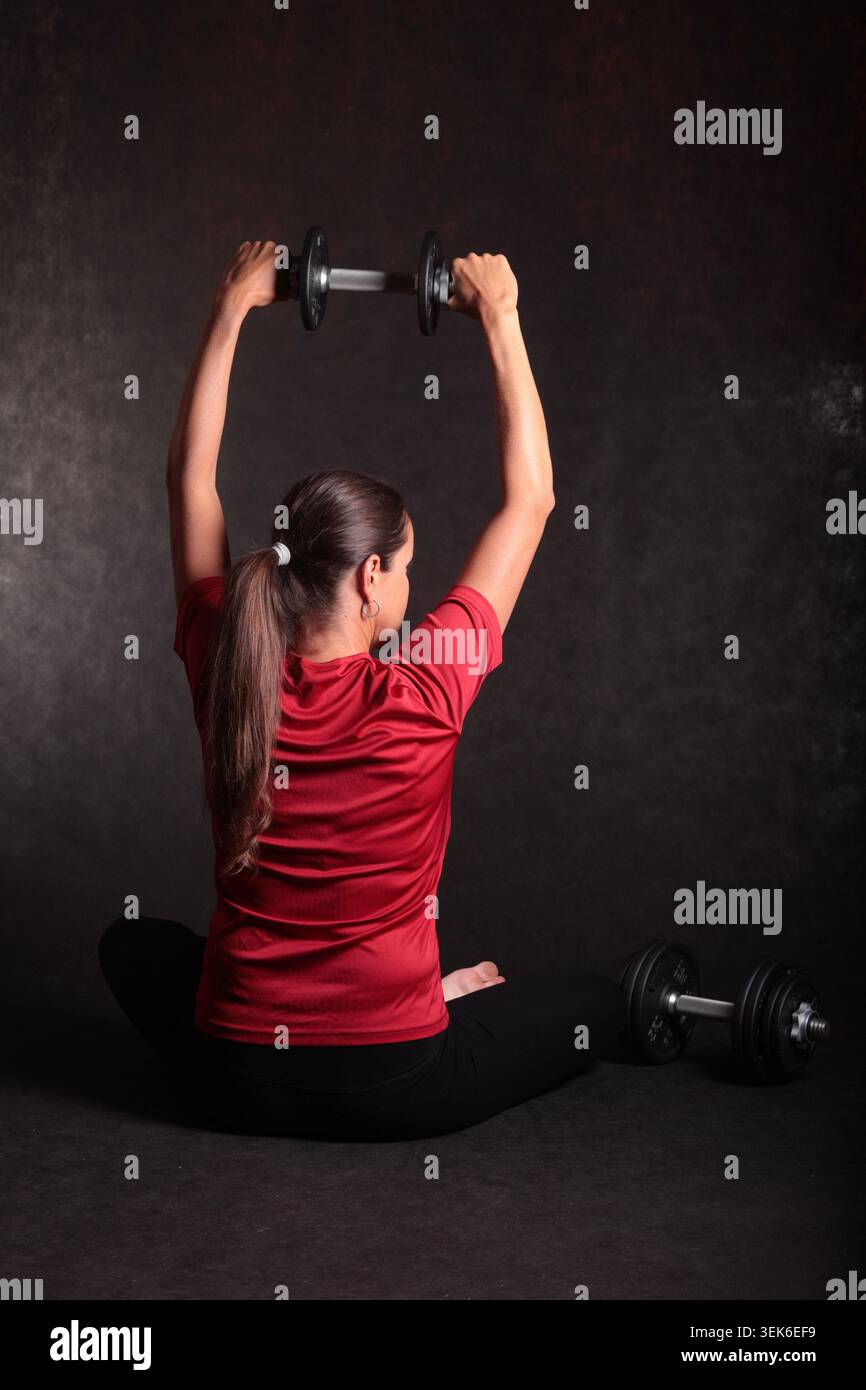 allenamento con manubri da pavimento incentrato sul movimento controllato e sull'attività di fitness disciplinata per la perdita di grasso Foto Stock