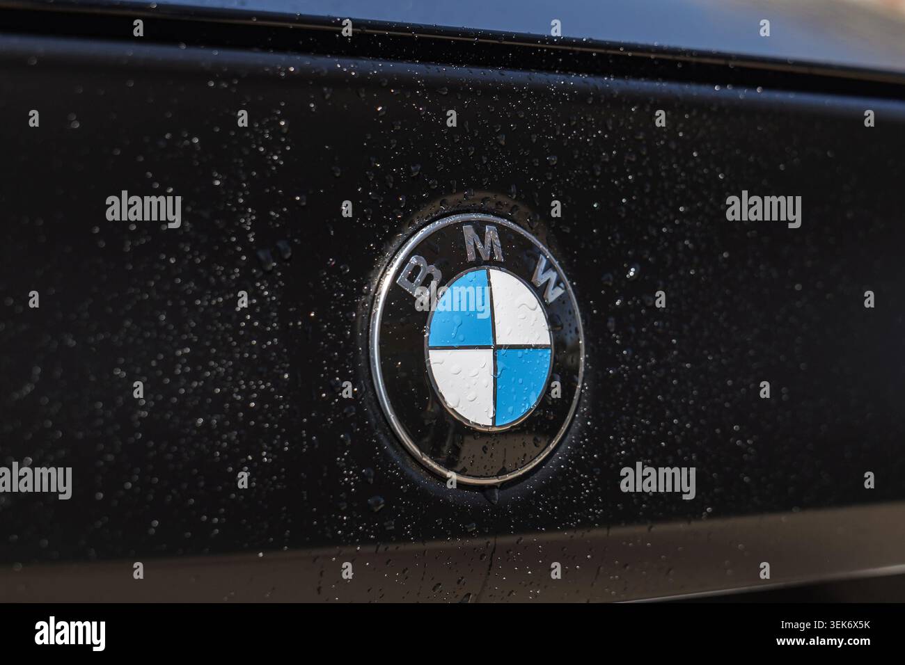 Slovenia, Lubiana - 8 aprile 2026: Gocce d'acqua sul logo BMW mostrano i dettagli del design dei marchi. Foto Stock