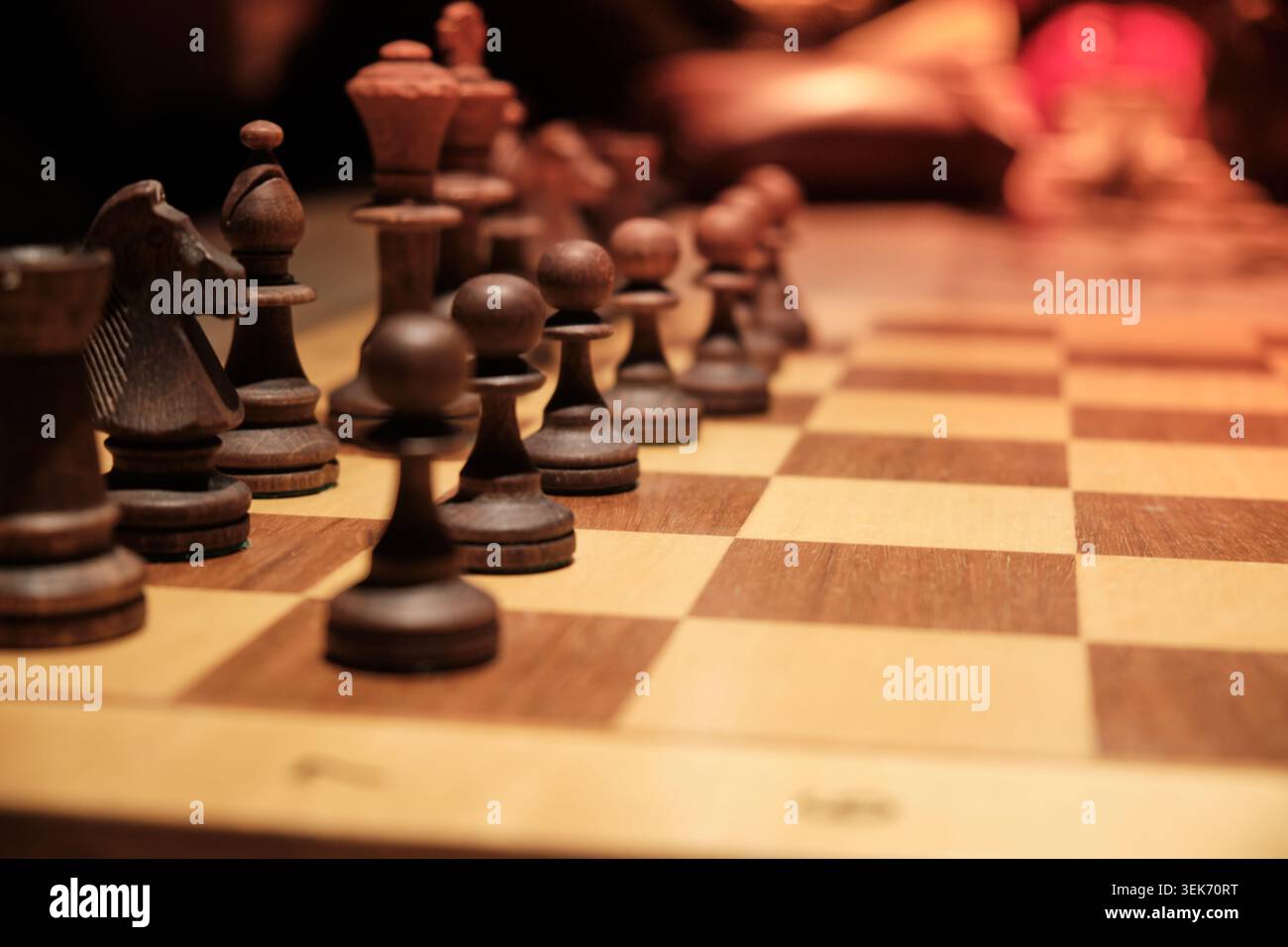 Scacchi di legno disposti su scacchiera durante la partita strategica Foto Stock