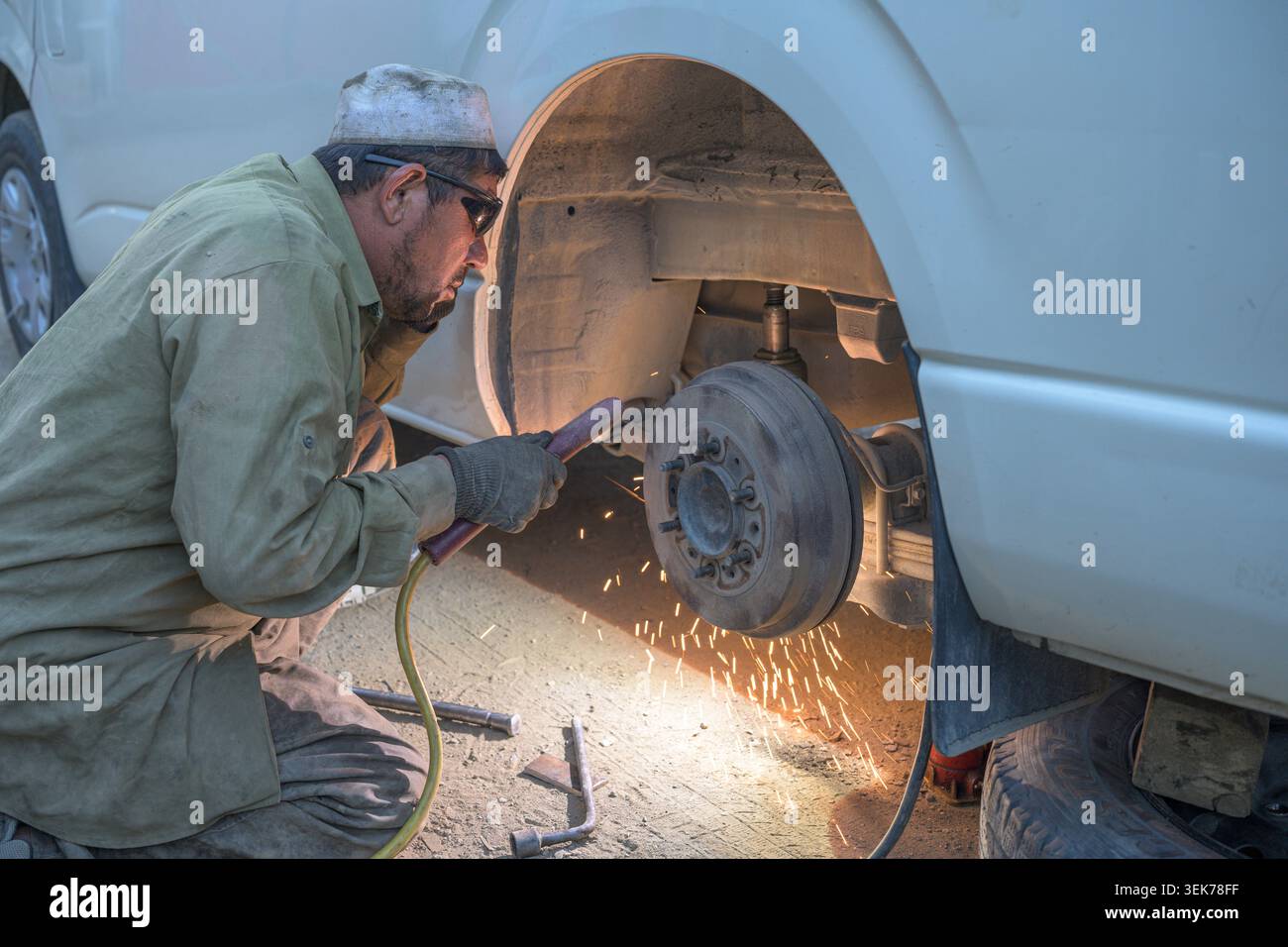 Meccanico afgano che ripara auto sulla strada hindu kush Foto Stock
