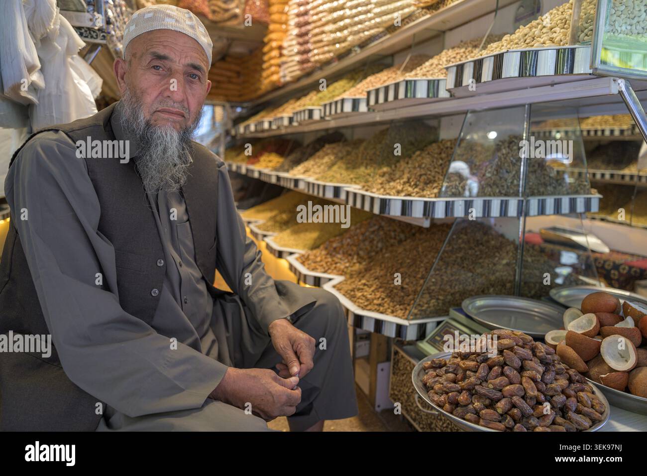 Uomo che vende frutta secca e noci in un mercato tradizionale Foto Stock