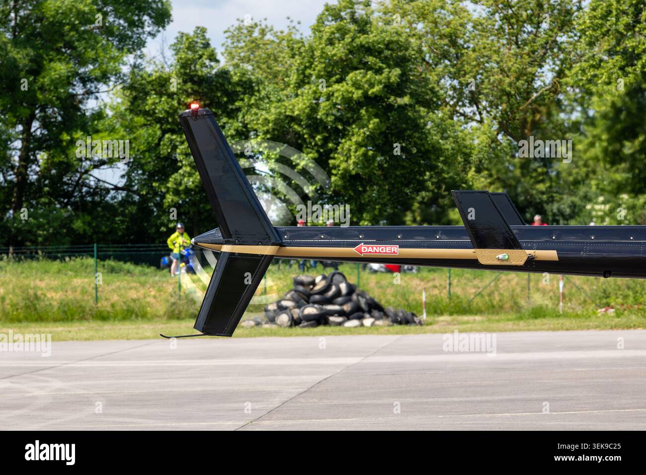 Vista ravvicinata della sezione di coda dell'elicottero che gira il rotore sopra la pavimentazione del campo d'aviazione. Dettagli tecnici aeronautici evidenziano i contrassegni di sicurezza, meccanici Foto Stock