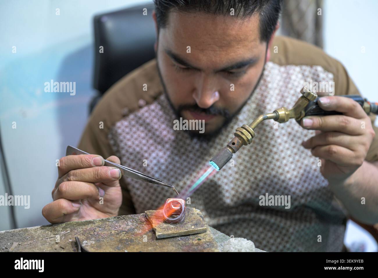 Artigiano sapientemente creare un anello utilizzando strumenti e tecniche tradizionali Foto Stock