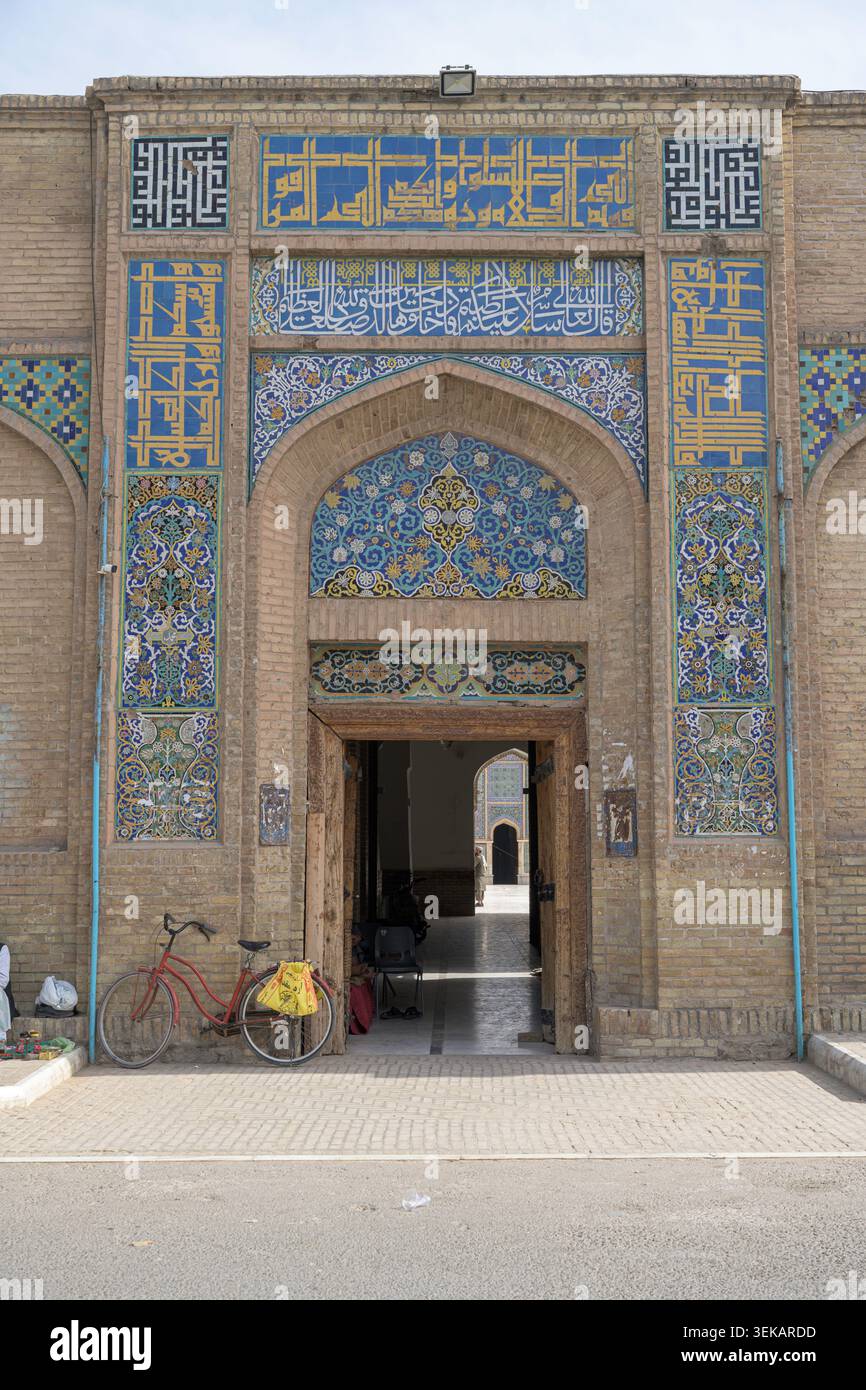 L'architettura storica della moschea mostra dettagliate piastrelle islamiche e motivi a mosaico. Vicino all'entrata ad arco si trova una bicicletta Foto Stock